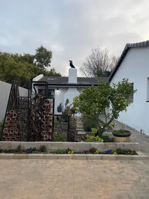 a white house with a gate and a garden at Seven in Secunda