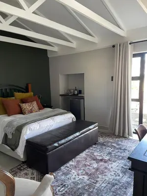 a bedroom with a bed with a black leather couch at Seven in Secunda