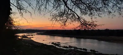 a view of a river at sunset at Rock'N Round Marloth Lodge in Marloth Park