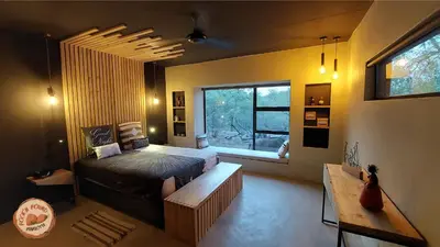 a bedroom with a bed and a large window at Rock'N Round Marloth Lodge in Marloth Park