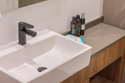 a white sink in a bathroom next to a counter at Menlyn Maine Luxury Studio King Bed Free parking 133 in Pretoria