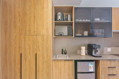 a kitchen with wooden cabinets and a counter with a sink at Menlyn Maine Luxury Studio King Bed Free parking 133 in Pretoria