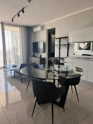 a dining room with a glass table and chairs at Kabazela at Ellipse in Midrand