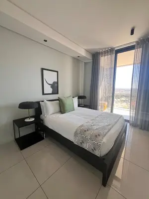a bedroom with a bed and a large window at Kabazela at Ellipse in Midrand