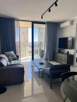 a living room with a couch and a table at Kabazela at Ellipse in Midrand