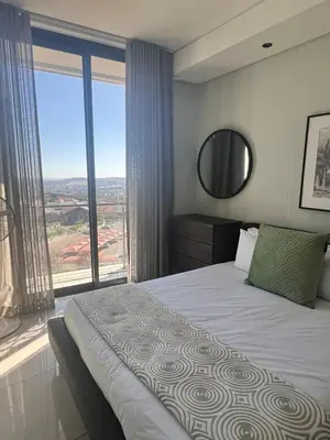a bedroom with a bed and a large window at Kabazela at Ellipse in Midrand