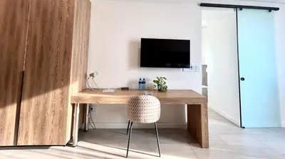 a room with a wooden desk with a television on a wall at Menlyn Maine Residence - Studio Apartment in Pretoria