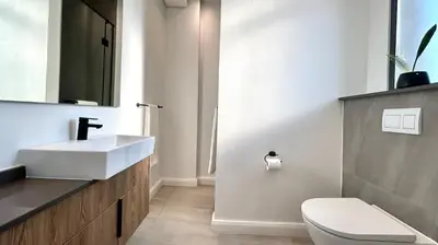 a bathroom with a white sink and a toilet at Menlyn Maine Residence - Studio Apartment in Pretoria