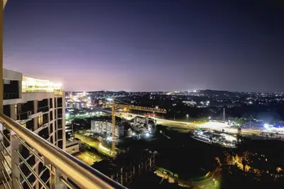 a view of a city at night with lights at Menlyn Maine Residence - Studio Apartment in Pretoria