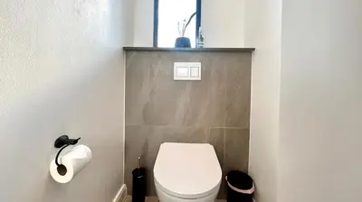 a bathroom with a toilet and a toilet paper dispenser at Menlyn Maine Residence - Studio Apartment in Pretoria