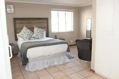 a bedroom with a large bed and a chair at Hepzibah Manor in White River