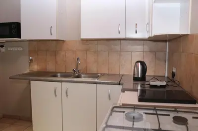 a kitchen with white cabinets and a sink at Hepzibah Manor in White River
