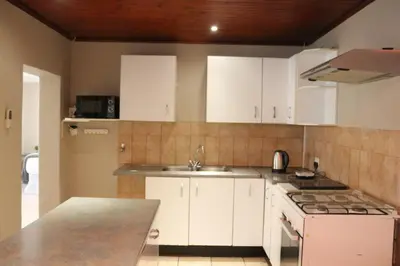 a kitchen with white cabinets and a sink at Hepzibah Manor in White River