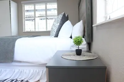 a bedroom with a bed and a table with a plant on it at Hepzibah Manor in White River
