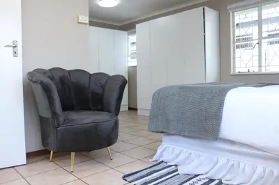 a bedroom with a black chair next to a bed at Hepzibah Manor in White River