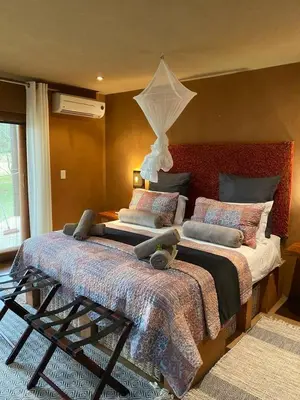 a bedroom with a large bed with pillows at Zebula - African Dream A - Pax 8 in Warmbaths