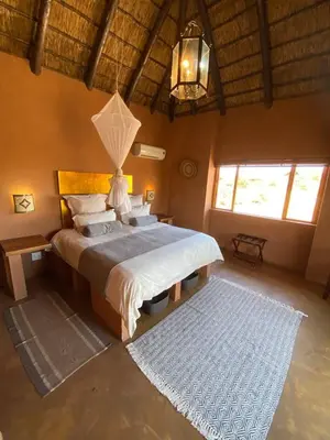 a bedroom with a large bed in a room at Zebula - African Dream A - Pax 8 in Warmbaths