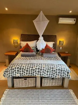 a bedroom with a large bed with an umbrella at Zebula - African Dream A - Pax 8 in Warmbaths
