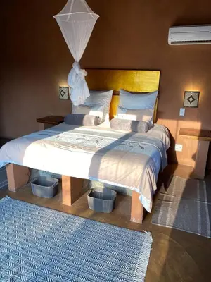 a bedroom with a large bed with a lamp on it at Zebula - African Dream A - Pax 8 in Warmbaths