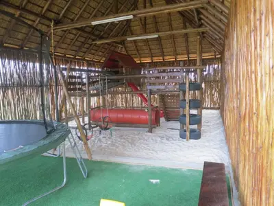 a playground in a straw hut with a swing at Zebula - African Dream A - Pax 8 in Warmbaths