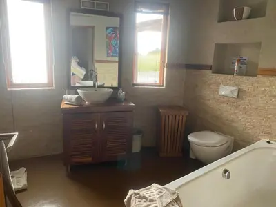 a bathroom with a tub and a sink and a toilet at Zebula - African Dream B - Pax 6 in Warmbaths
