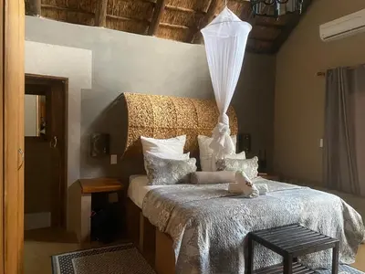 a bedroom with a bed with a teddy bear on it at Zebula - African Dream B - Pax 6 in Warmbaths
