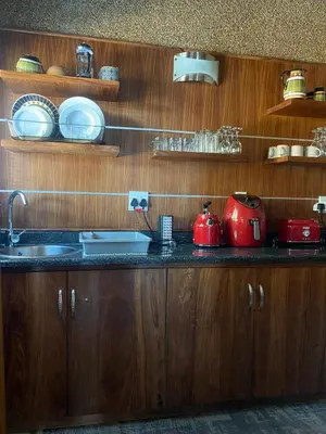 a kitchen with wooden cabinets and a counter with pots and pans at Zebula - African Dream B - Pax 6 in Warmbaths