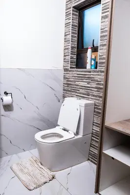 a bathroom with a white toilet and a window at Bendor Escape - Peace Privacy Power in Polokwane