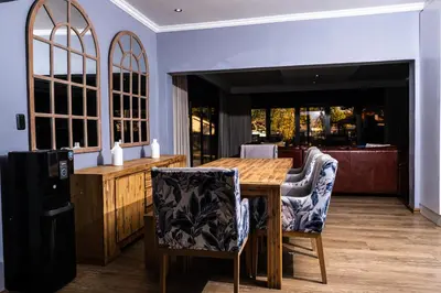 a dining room with a wooden table and chairs at Bendor Escape - Peace Privacy Power in Polokwane