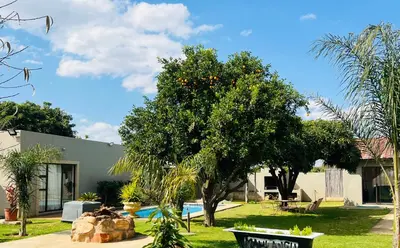 a house with an orange tree in the yard at The Village Haven Lodge