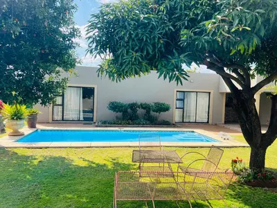 a swimming pool in a yard with a tree at The Village Haven Lodge
