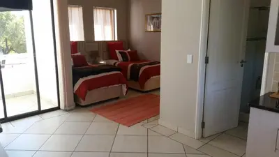 a living room with two beds in a room at Casa Bianca Guest Lodge in Hartbeespoort