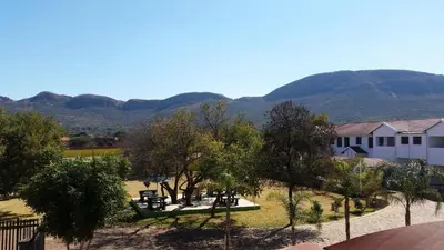 a view of a park with mountains in the background at Casa Bianca Guest Lodge in Hartbeespoort