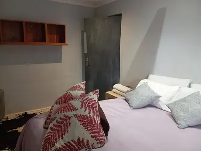 a bedroom with a bed with pillows on it at The Chardonnay Inn in Centurion