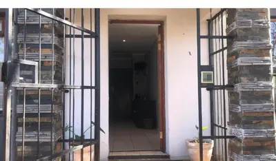 a room with a door leading to a hallway with a stack of books at The Chardonnay Inn in Centurion