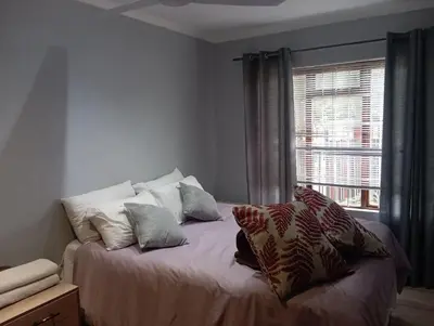 a bedroom with a bed with pillows and a window at The Chardonnay Inn in Centurion