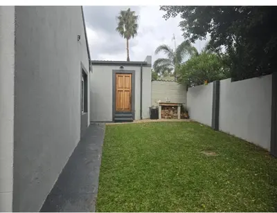 a house with a yard with a wooden door at The Chardonnay Inn in Centurion