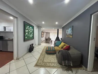 a living room with a couch and a kitchen at DullVino Wellington House in Dullstroom