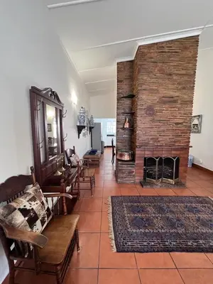 a living room with a large brick fireplace at Palm House Accommodation White River in White River