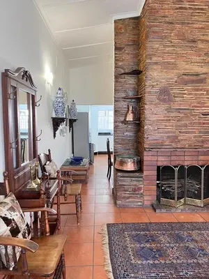 a living room with a large brick fireplace at Palm House Accommodation White River in White River