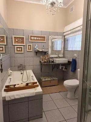 a bathroom with a tub and a sink and a toilet at Palm House Accommodation White River in White River
