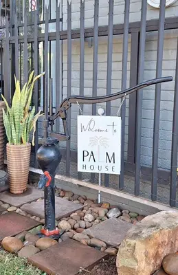 a sign on a fence with a plan m house at Palm House Accommodation White River in White River