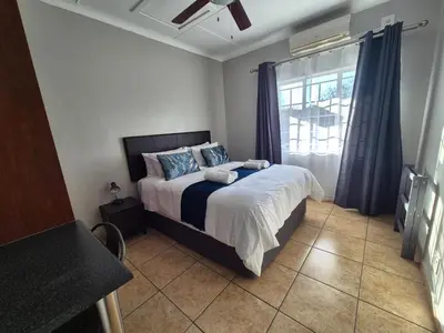 a bedroom with a bed and a window at 5 On Park in Phalaborwa