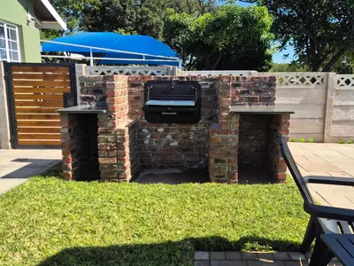 a barbecue grill on a brick wall in a yard at 5 On Park in Phalaborwa