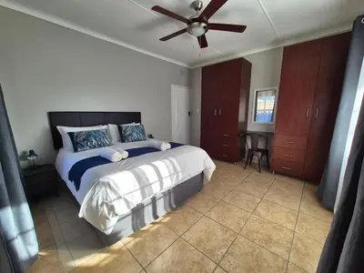 a bedroom with a bed and a ceiling fan at 5 On Park in Phalaborwa