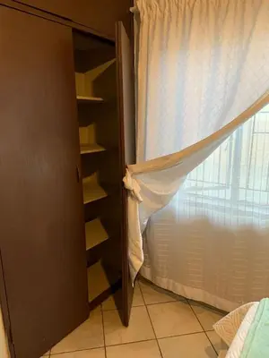 a room with a closet with a curtain and a window at Epizone in Mokopane