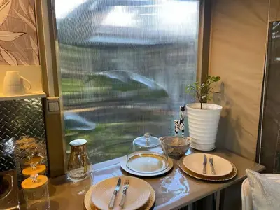 a table with plates and utensils and a window at African Paradise - Garden Glamping - Outdoor Shower in Benoni