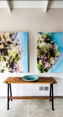 a table in a room with two paintings on the wall at Rusgerus in Pretoria