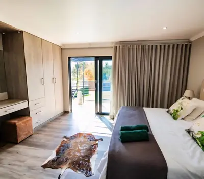 a bedroom with a large bed and a sliding glass door at Rusgerus in Pretoria