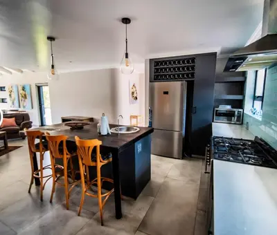 a kitchen with a table and chairs and a stove at Rusgerus in Pretoria